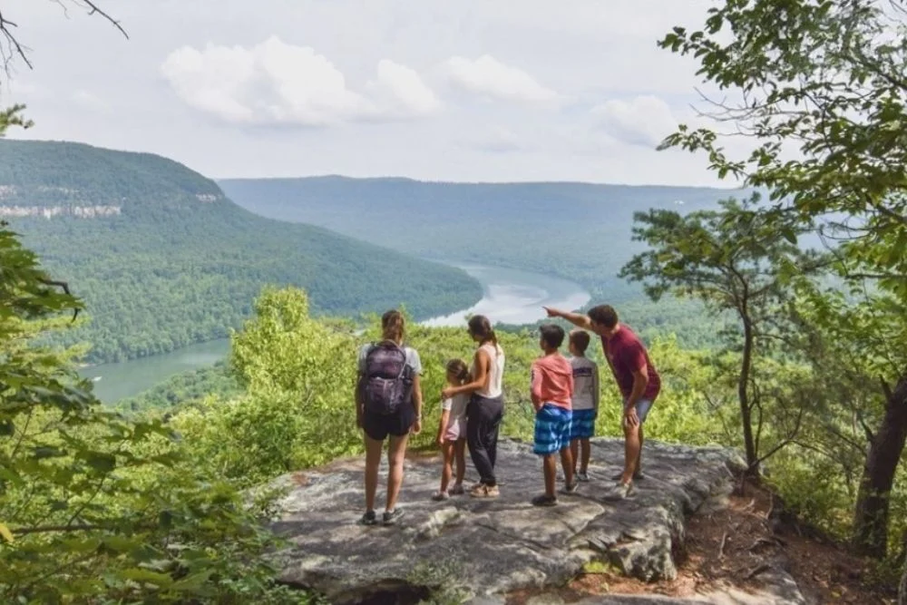 Family enjoying scenic view of mountains and river, highlighting outdoor lifestyle near Pratt Home Builders in Chattanooga TN.