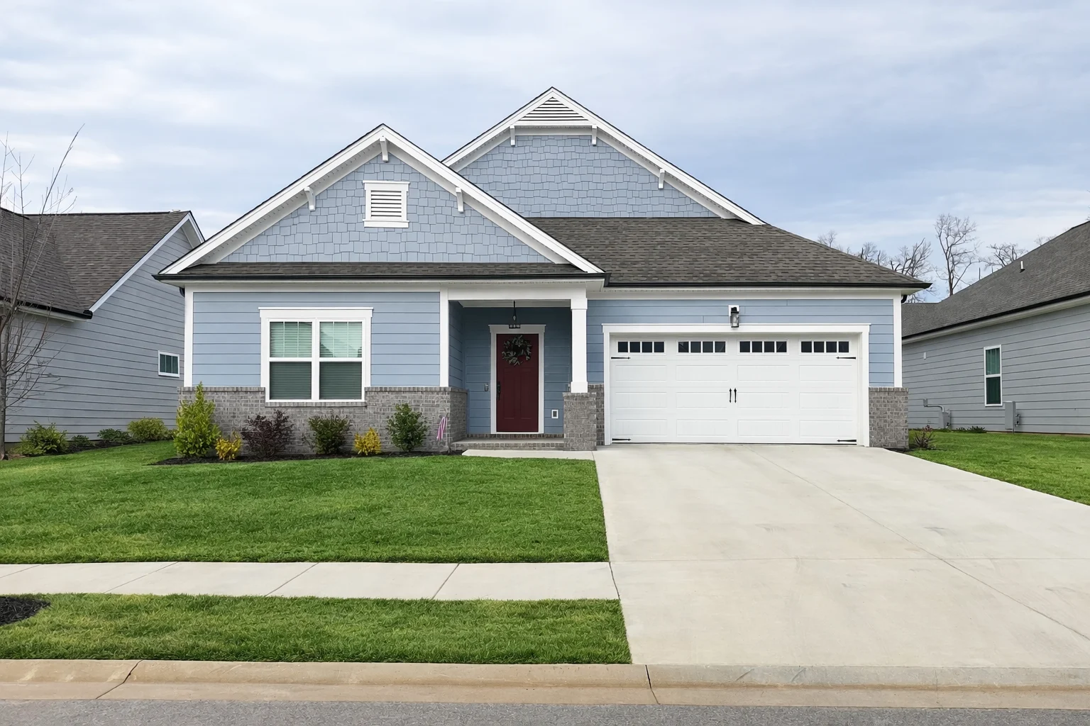 Single-story blue house with gable roof, front porch, and manicured lawn. Built by Pratt Home Builders in Chattanooga TN.