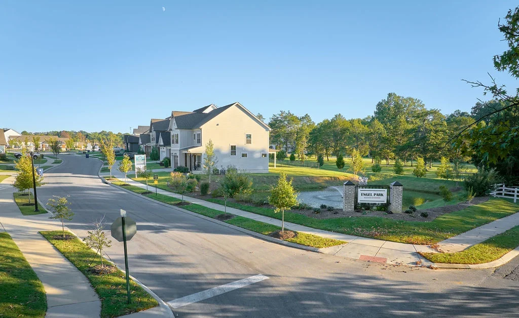 Engel Park new construction homes now selling Chattanooga TN. New Home Chattanooga TN. Suburban street with modern homes and manicured lawns. Signs for Engel Park and Pratt Home Builders visible.