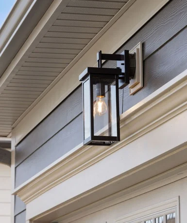 Outdoor lantern sconce on a modern home's exterior by Pratt Home Builders in Chattanooga TN, featuring a black frame and suspended bulb.