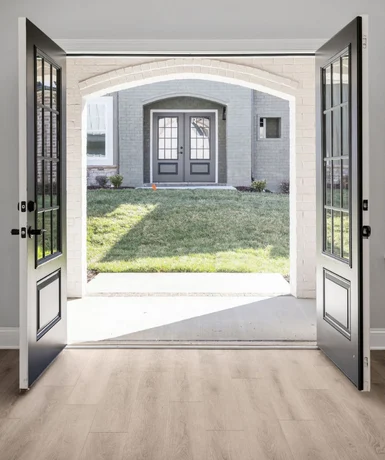 Open double doors leading to a sunlit patio and grassy yard, featuring elegant architecture by Pratt Home Builders in Chattanooga TN.