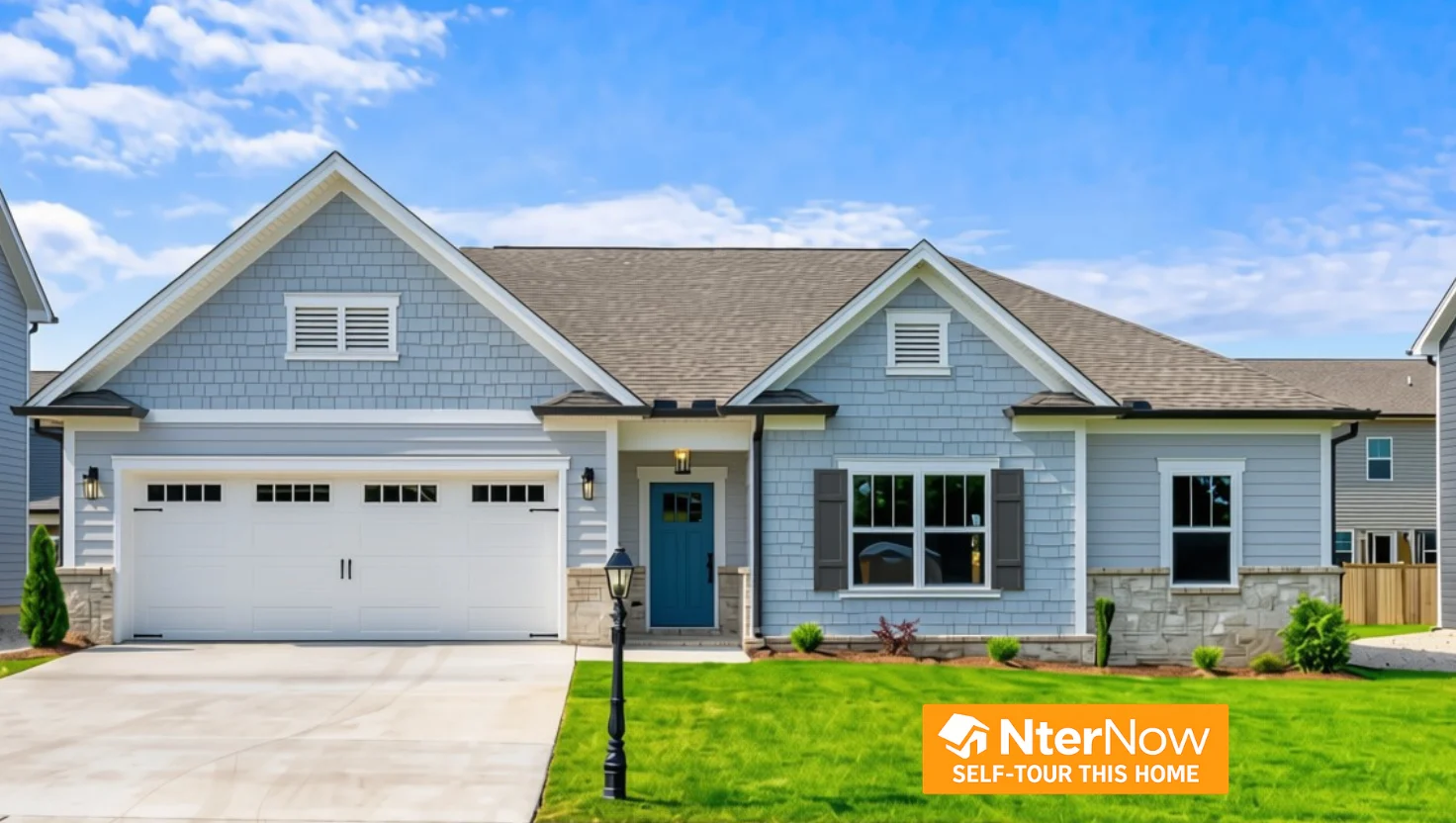 Modern suburban home with blue siding and a two-car garage by Pratt Home Builders in Chattanooga TN, featuring a lush front lawn and sunny skies.