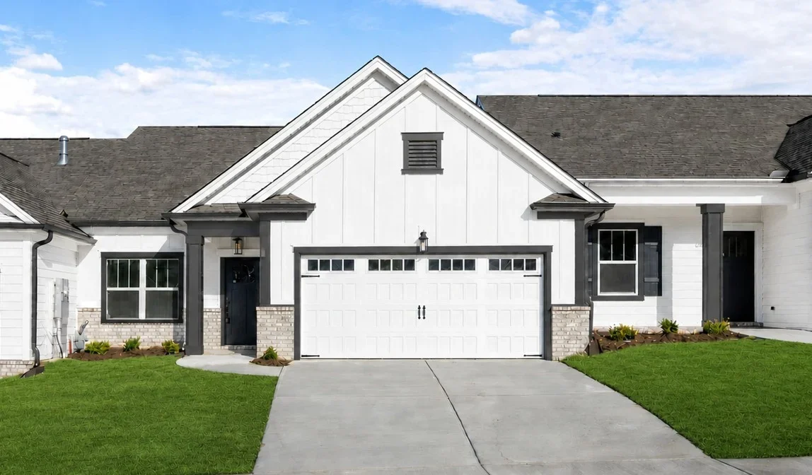 Modern single-story home with white siding, dark trim, and a two-car garage, built by Pratt Home Builders in Chattanooga TN.