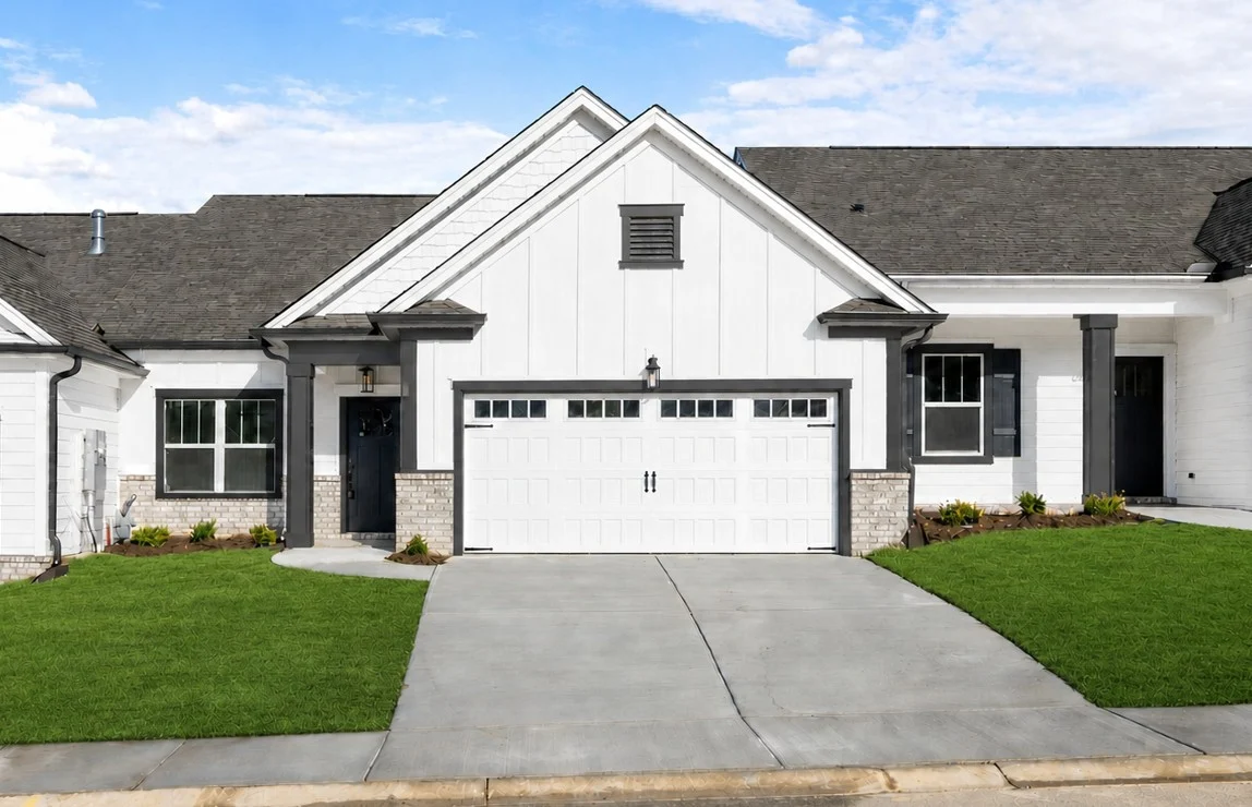 Modern single-story home with white siding, dark trim, and a two-car garage, built by Pratt Home Builders in Chattanooga TN.