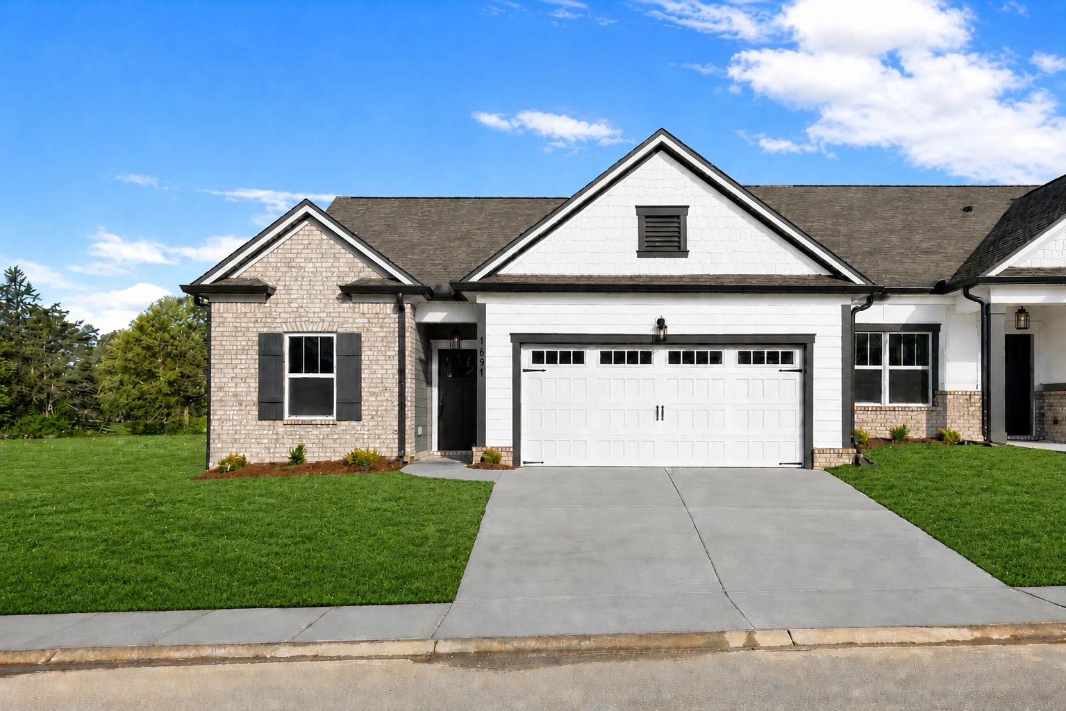 Single-story home with brick and white siding, landscaped yard, and double garage by Pratt Home Builders in Chattanooga TN.