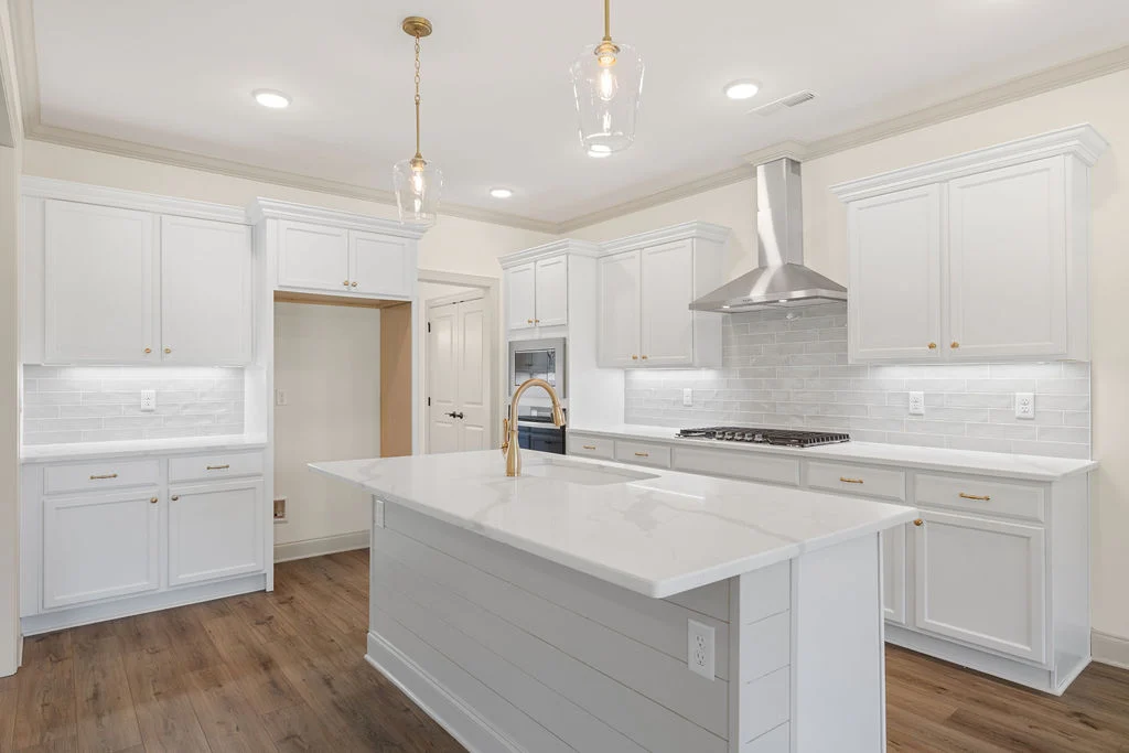 Spacious kitchen by Pratt Home Builders in Chattanooga TN, featuring white cabinets, stainless steel appliances, and a central island with pendant lig