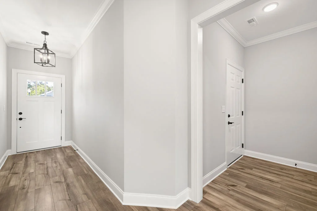 Bright entryway with wood flooring, white doors, and modern light fixture, designed by Pratt Home Builders in Chattanooga TN.