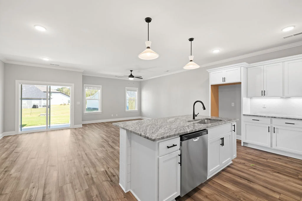 Spacious open-concept kitchen and living area with wood floors, island, and large windows by Pratt Home Builders in Chattanooga, TN.