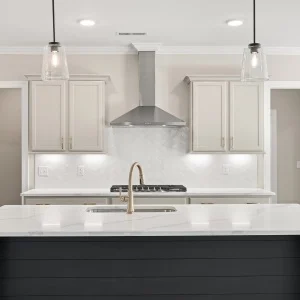 Modern kitchen design with marble island, pendant lights, sleek faucet, and cabinetry by Pratt Home Builders in Chattanooga TN.