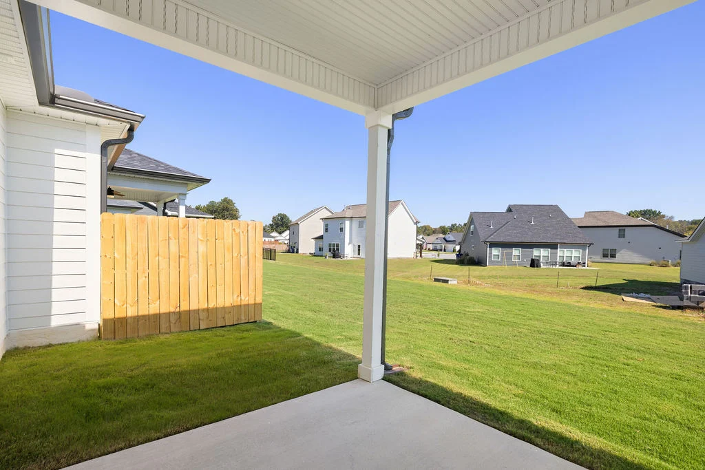 Covered patio overlooking a grassy backyard and neighboring homes, showcasing Pratt Home Builders in Chattanooga TN.