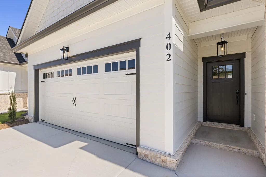 White garage with dark door, house number 402. Clean, modern entryway by Pratt Home Builders in Chattanooga TN.