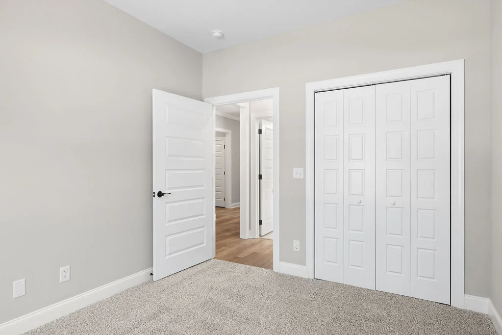 White interior doors with modern design, beige walls, carpet flooring. Highlighting craftsmanship by Pratt Home Builders in Chattanooga TN.