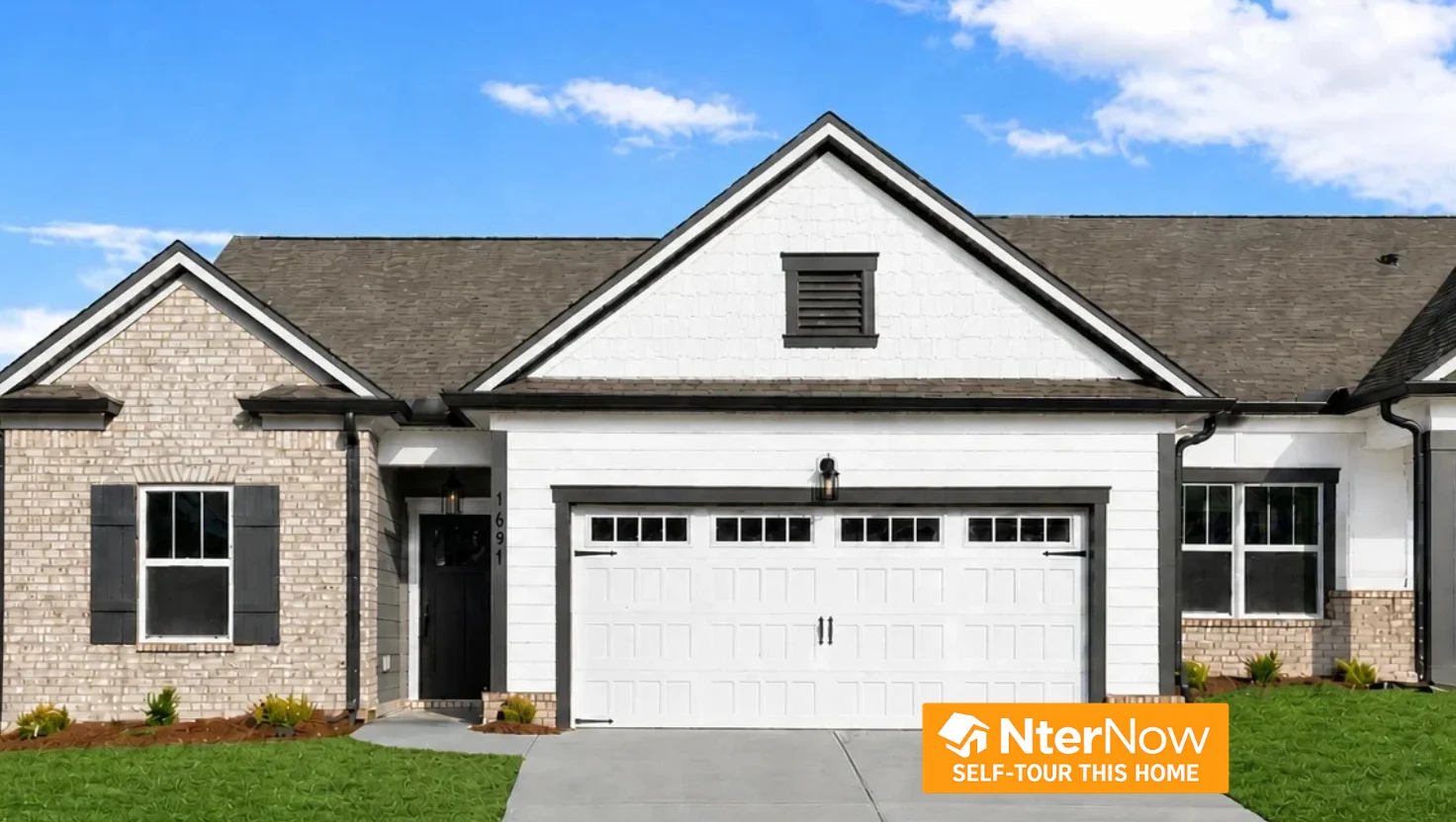 Modern single-story home with white siding and brick accents by Pratt Home Builders in Chattanooga TN, featuring a two-car garage and self-tour option