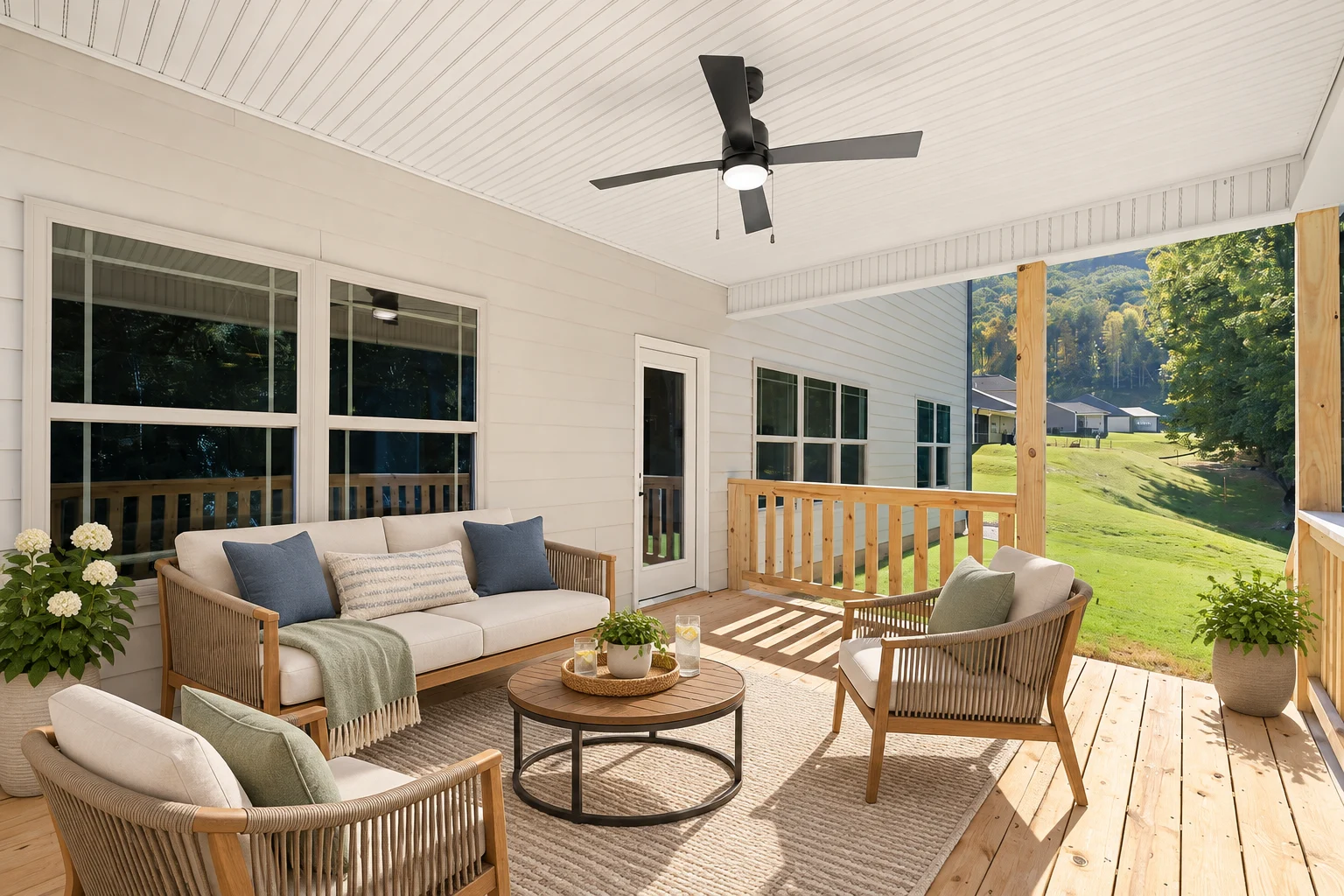 Cozy covered patio with comfy seating, ceiling fan, and lush view by Pratt Home Builders in Chattanooga TN.