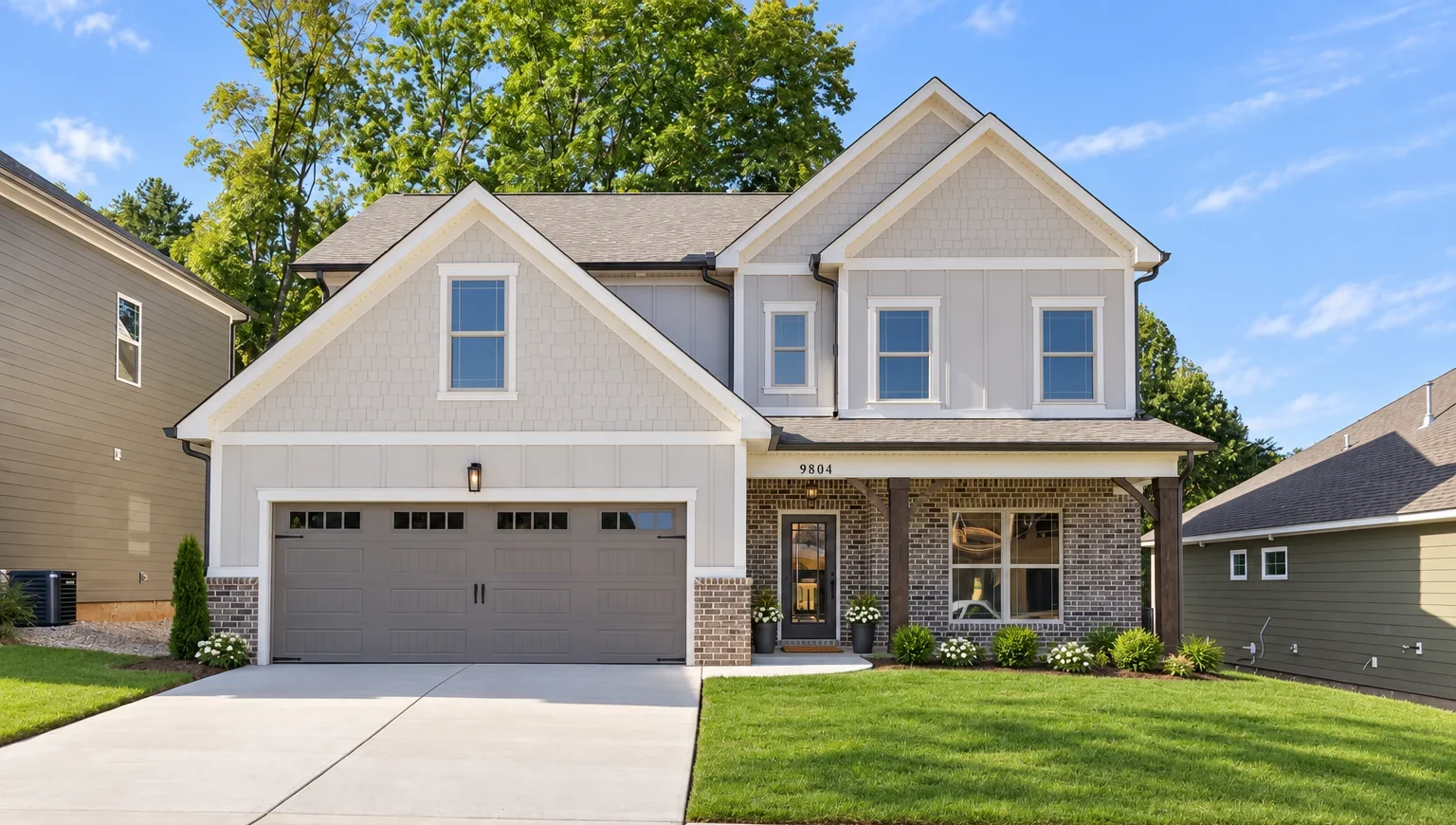 Modern two-story home with gray siding, a double garage, and a manicured lawn by Pratt Home Builders in Chattanooga TN.