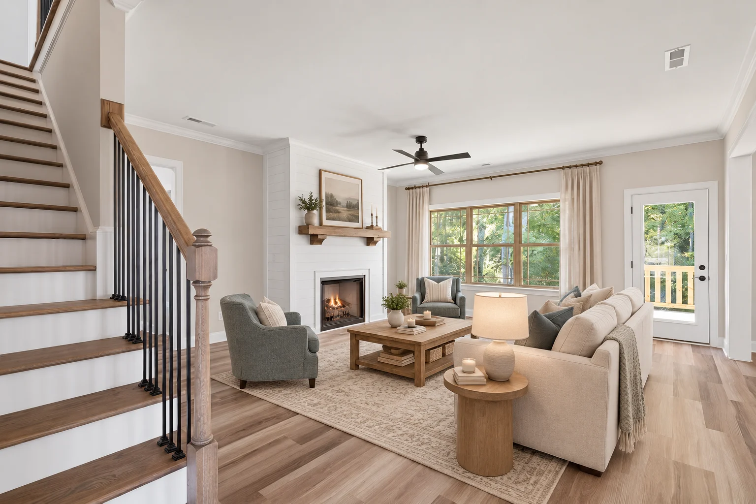 Elegant living room by Pratt Home Builders in Chattanooga, TN. Cozy seating, fireplace, large windows, and light wood floors create a welcoming space.