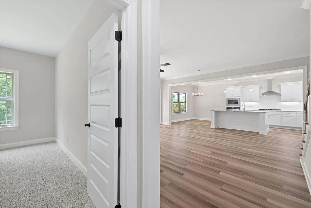 Spacious open-concept kitchen and living area with hardwood floors, modern fixtures by Pratt Home Builders in Chattanooga TN.