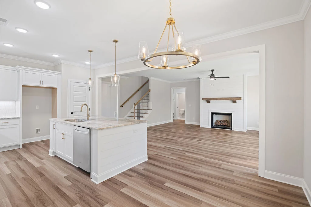 Spacious open-concept kitchen and living area with hardwood floors, modern fixtures, and fireplace by Pratt Home Builders in Chattanooga, TN.