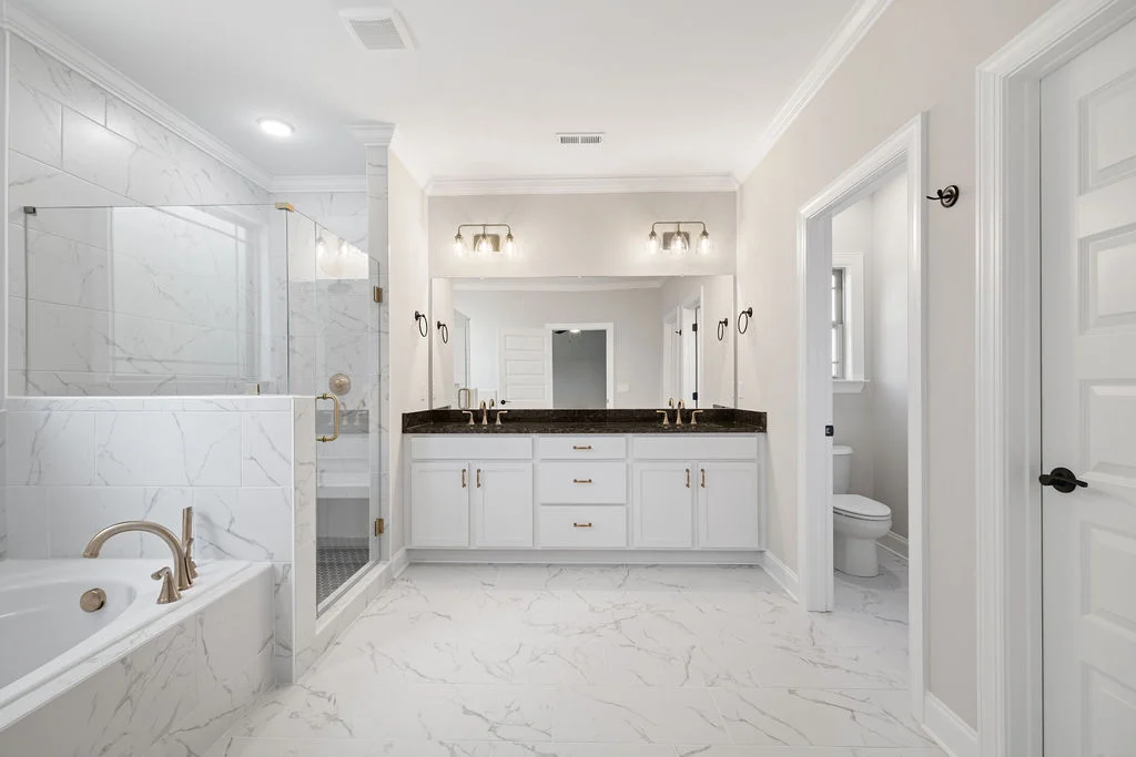 Elegant marble bathroom with dual sinks, tub, glass shower. Designed by Pratt Home Builders in Chattanooga TN.