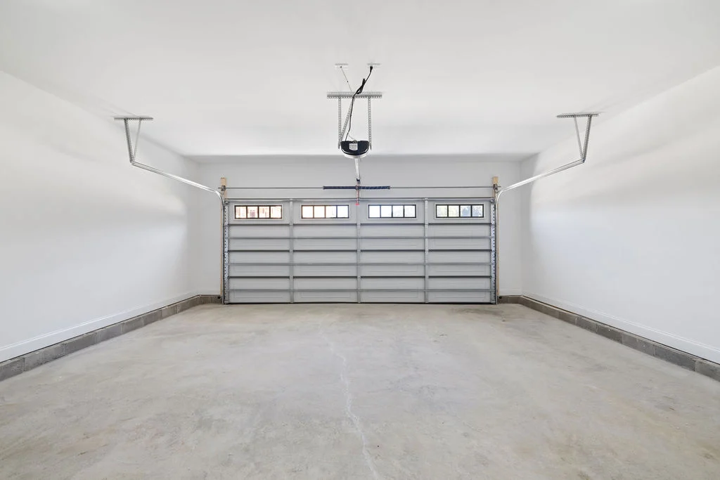 Spacious, empty garage with a modern overhead door by Pratt Home Builders in Chattanooga, TN.