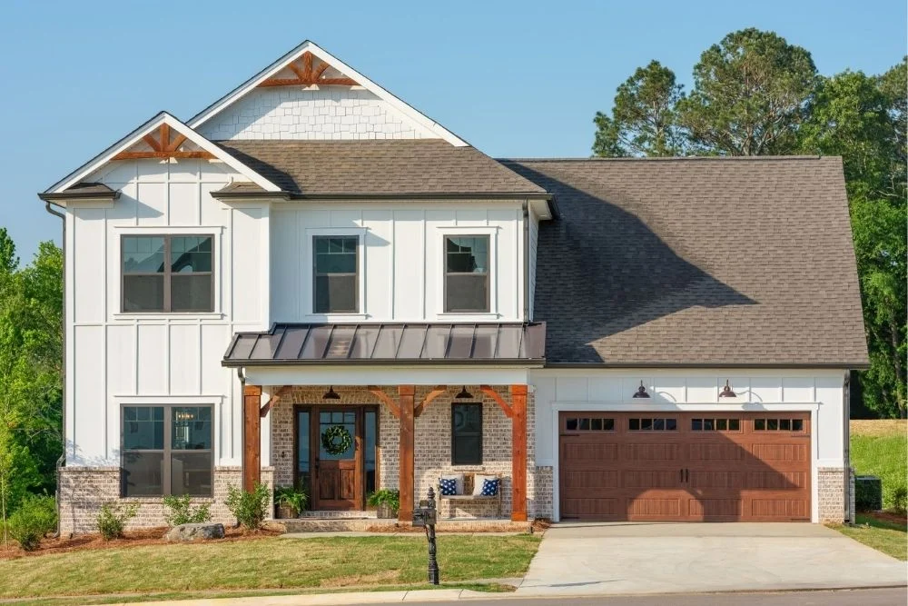 Two-story white house with wood accents, brick details, large garage, designed by Pratt Home Builders in Chattanooga TN.
