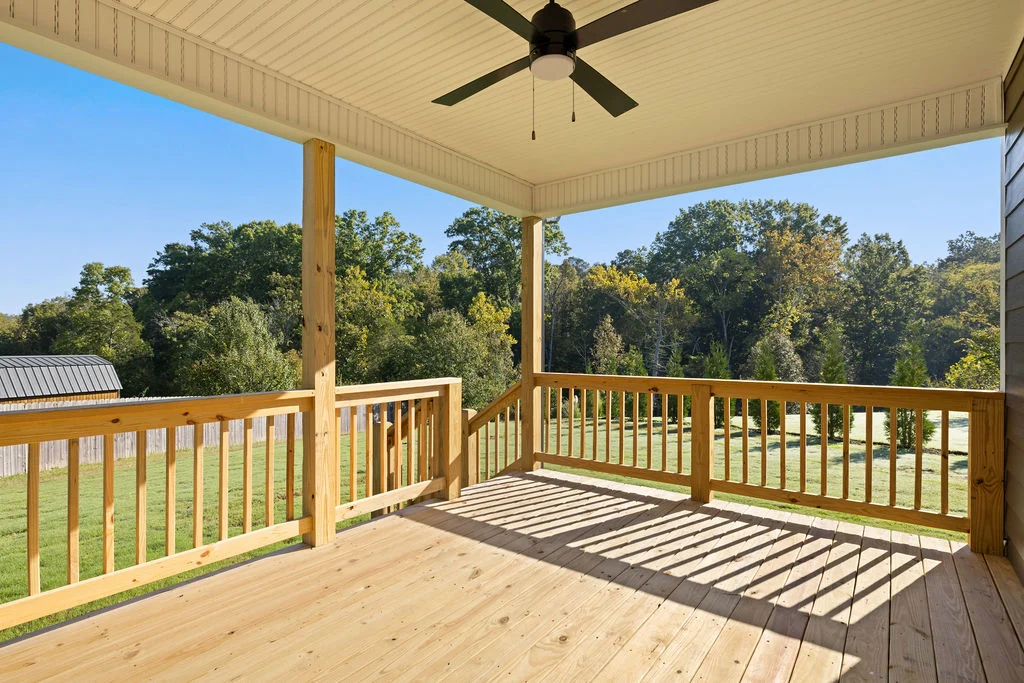 Wooden porch with ceiling fan overlooking lush green yard and trees, built by Pratt Home Builders in Chattanooga TN.