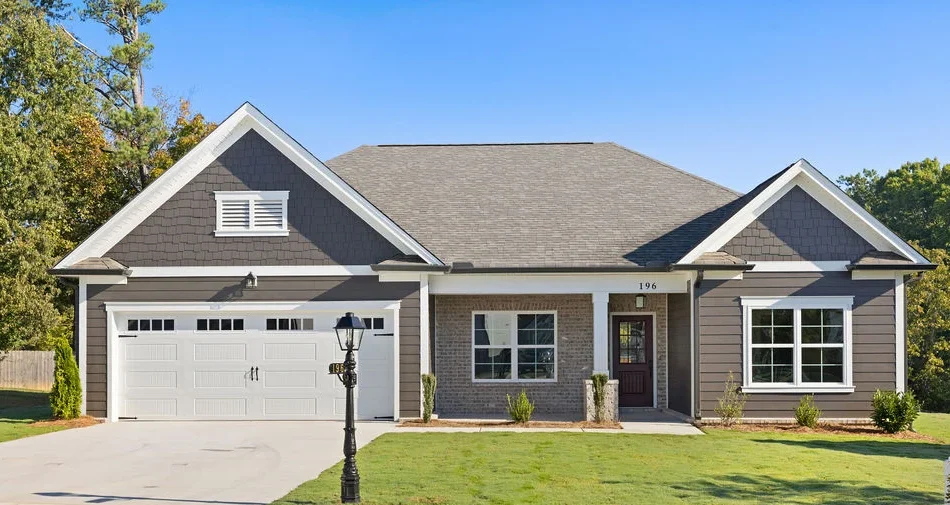 Modern single-story home with gray siding, white garage door, and manicured lawn by Pratt Home Builders in Chattanooga, TN.