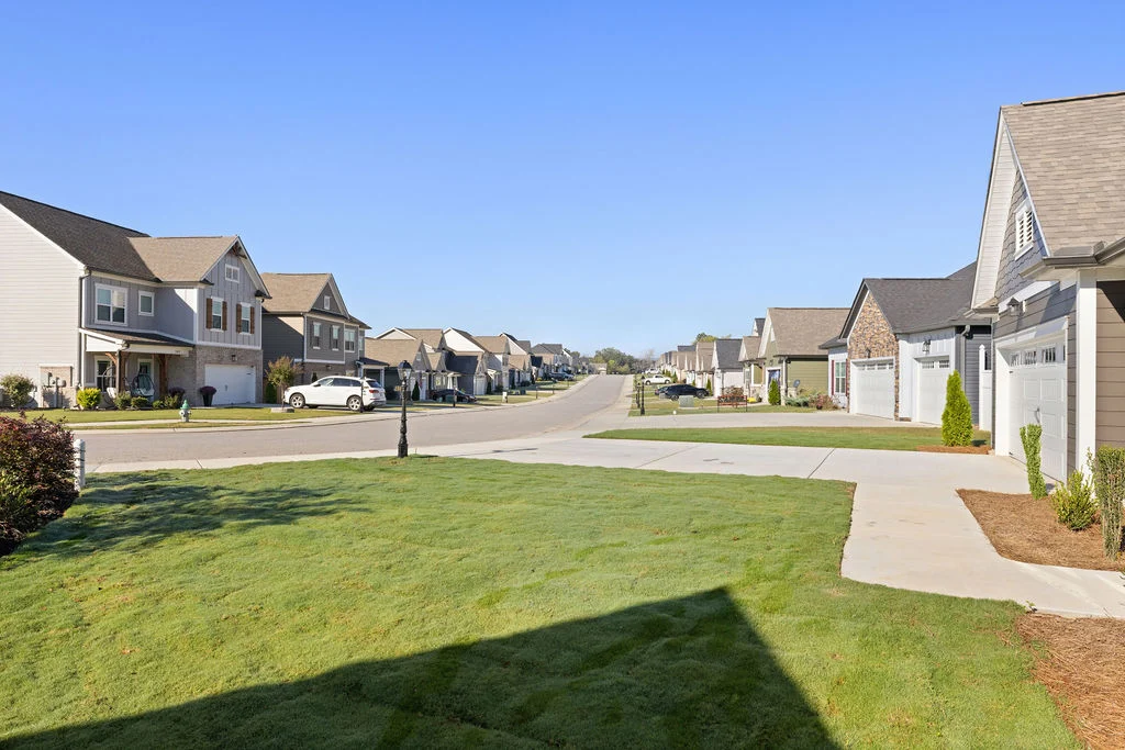 Suburban neighborhood with rows of modern homes under a clear blue sky, featuring Pratt Home Builders in Chattanooga, TN.