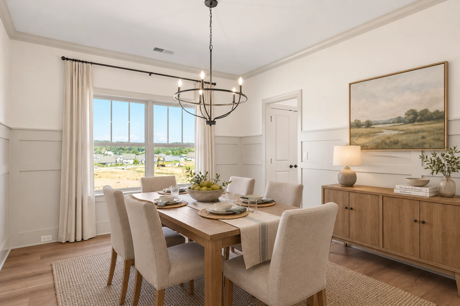 Elegant dining room by Pratt Home Builders in Chattanooga TN, features a wooden table, six chairs, chandelier, and scenic view through large window.