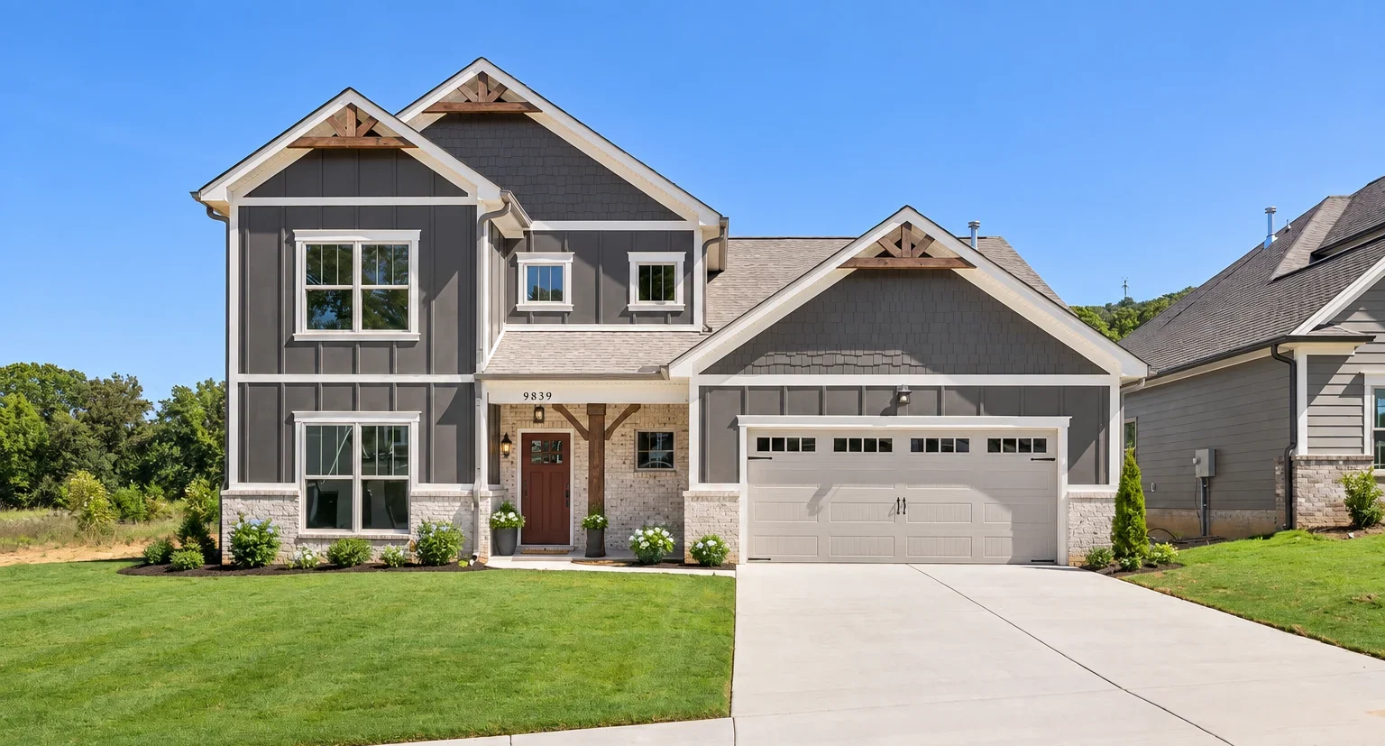 Modern two-story gray house with white trimming, spacious driveway, and manicured lawn by Pratt Home Builders in Chattanooga TN.