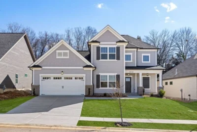 Two-story house with gray siding and black shutters, a white garage, and neatly manicured lawn by Pratt Home Builders in Chattanooga TN.