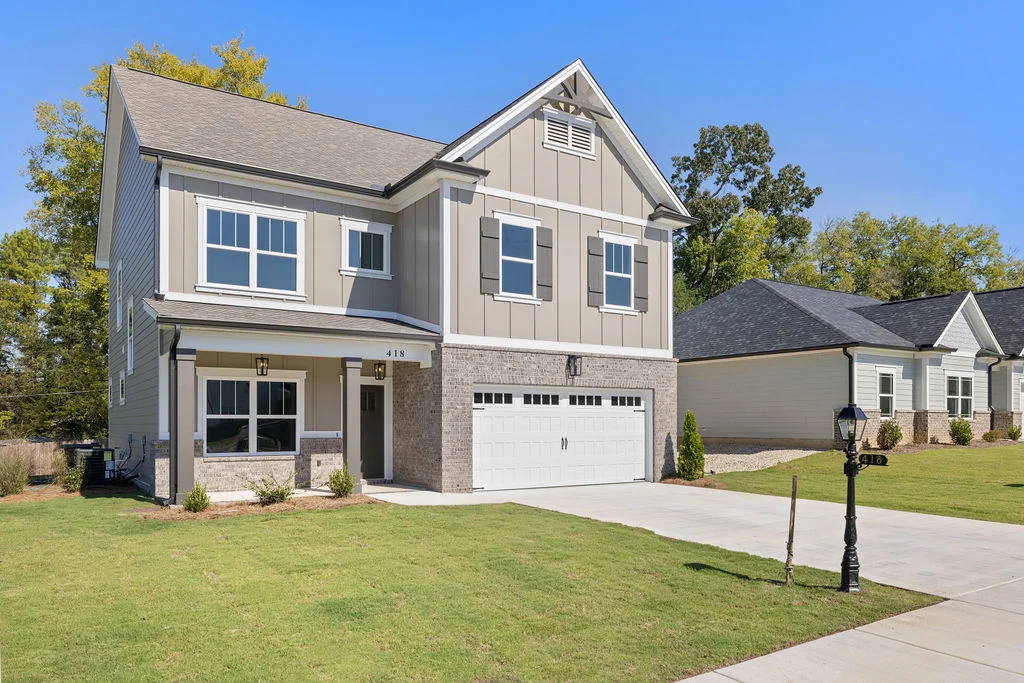 Two-story modern house with a gray facade, well-maintained lawn, and a two-car garage. Built by Pratt Home Builders in Chattanooga, TN.