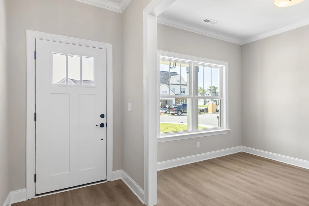Bright entryway featuring a white door and large window by Pratt Home Builders in Chattanooga TN, showcasing modern interior design.