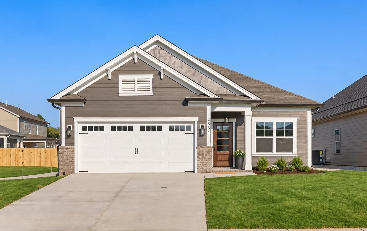 Modern single-story home by Pratt Home Builders in Chattanooga TN, featuring a two-car garage, neatly trimmed lawn, and brick accents.