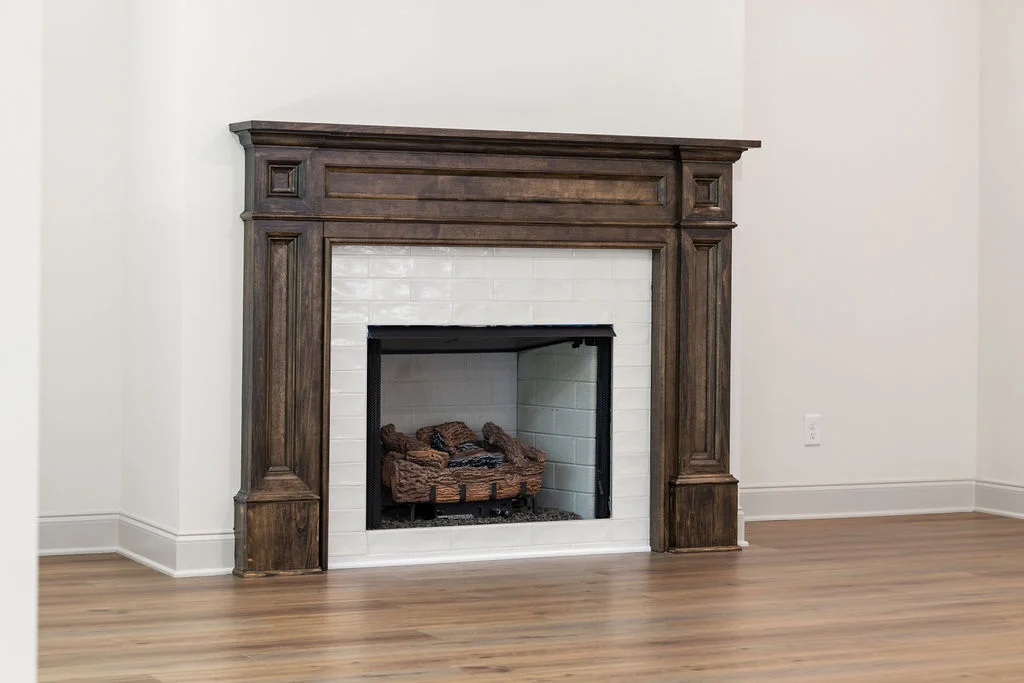 Elegant fireplace with rich wood mantel and white tile, showcasing Pratt Home Builders' craftsmanship in Chattanooga, TN.