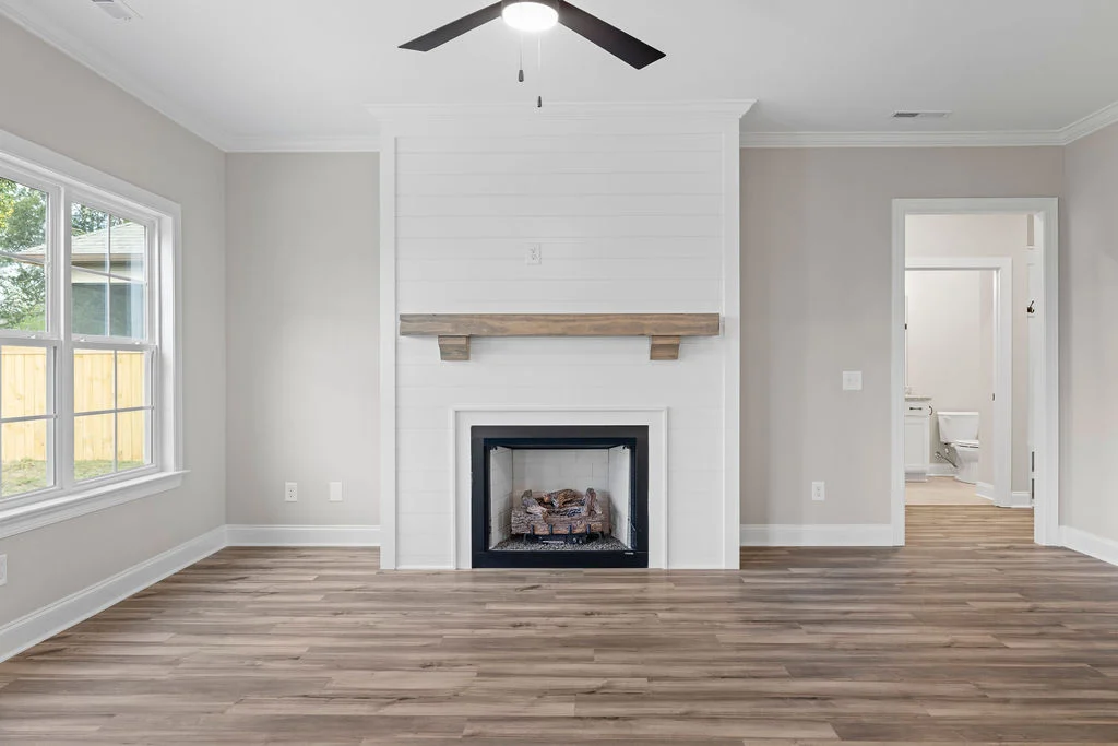 Modern living room with shiplap fireplace, wood mantel, and elegant flooring by Pratt Home Builders in Chattanooga, TN.