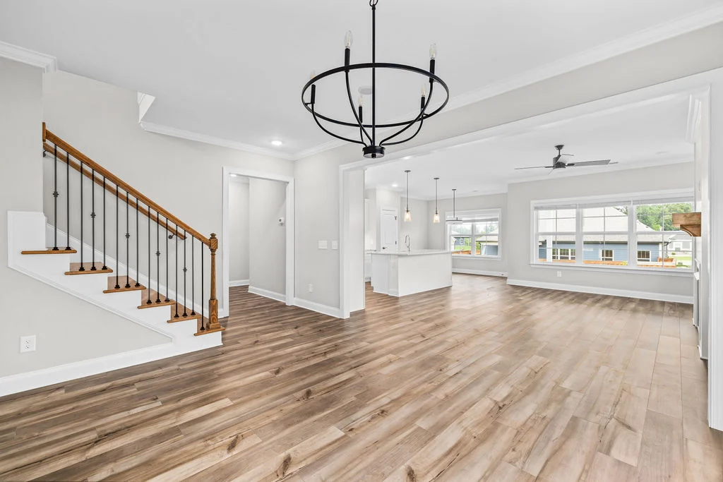Open-concept living area by Pratt Home Builders in Chattanooga TN, featuring light wood flooring, modern fixtures, and natural lighting.