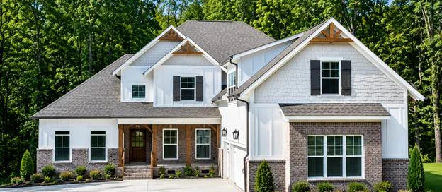 Spacious suburban home with brick and white siding, lush landscaping, located in a wooded area, built by Pratt Home Builders in Chattanooga TN.