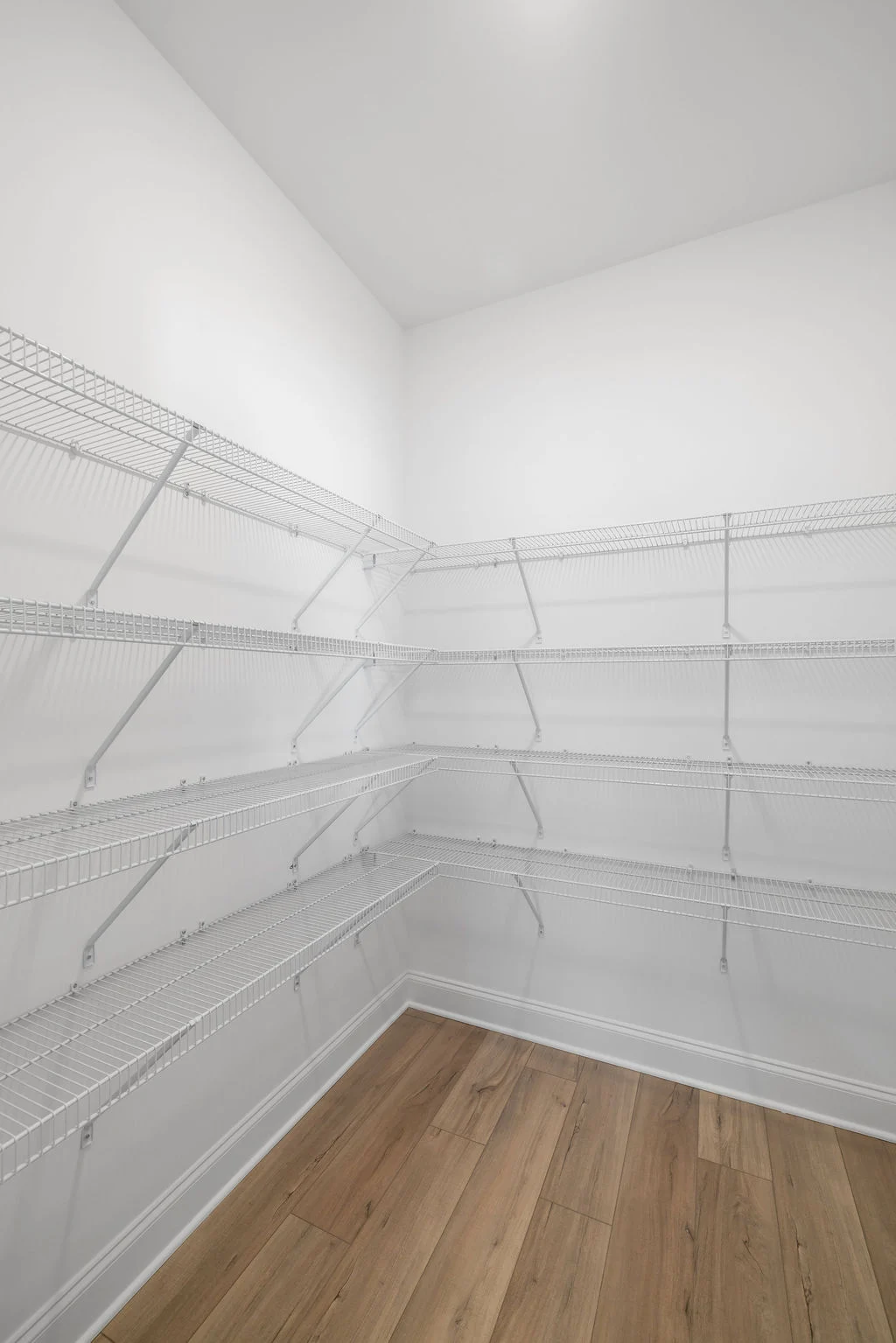 Spacious pantry with wire shelving and wooden flooring by Pratt Home Builders in Chattanooga TN.