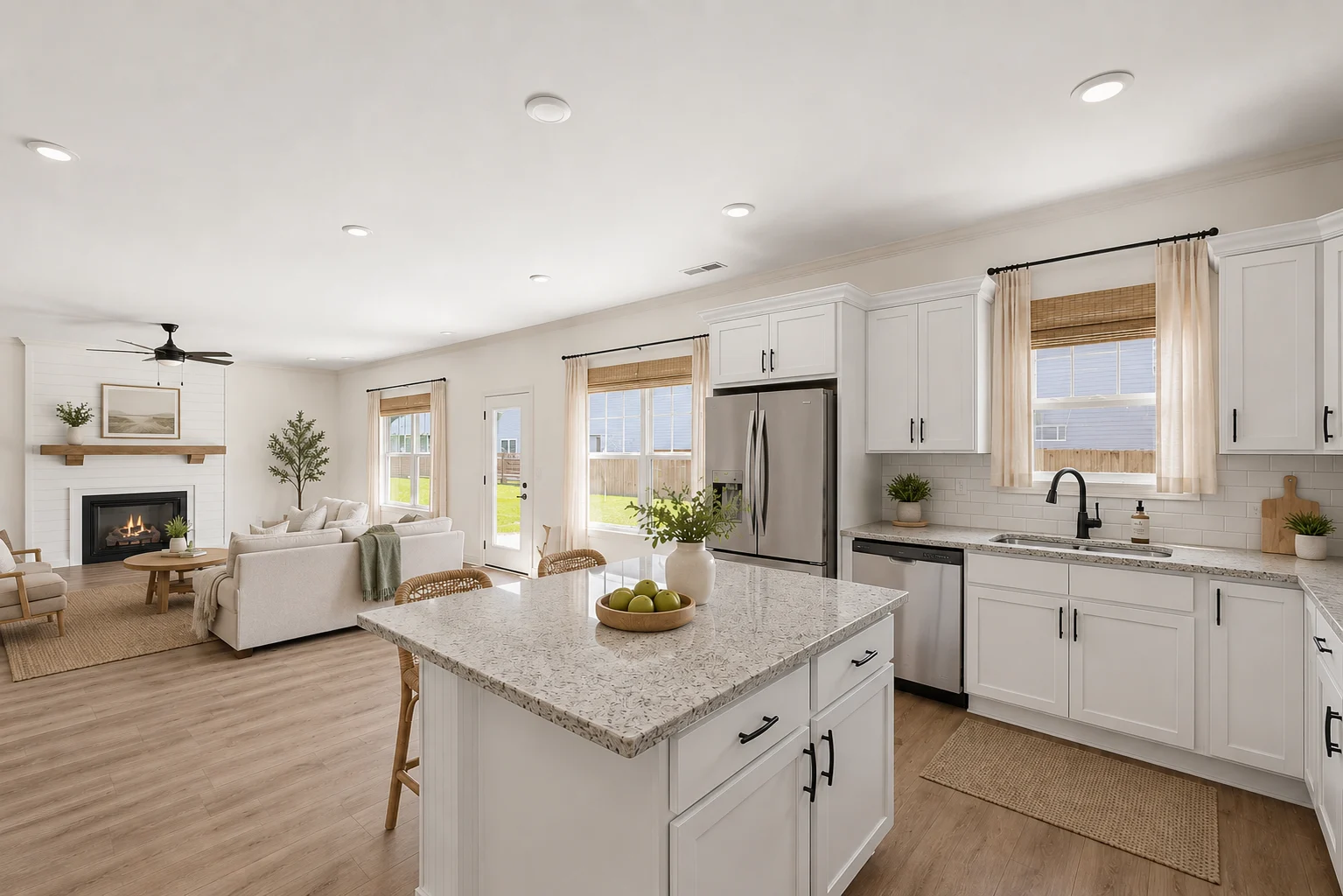 Spacious modern kitchen and living area by Pratt Home Builders in Chattanooga TN, featuring white cabinets, island, and cozy fireplace.