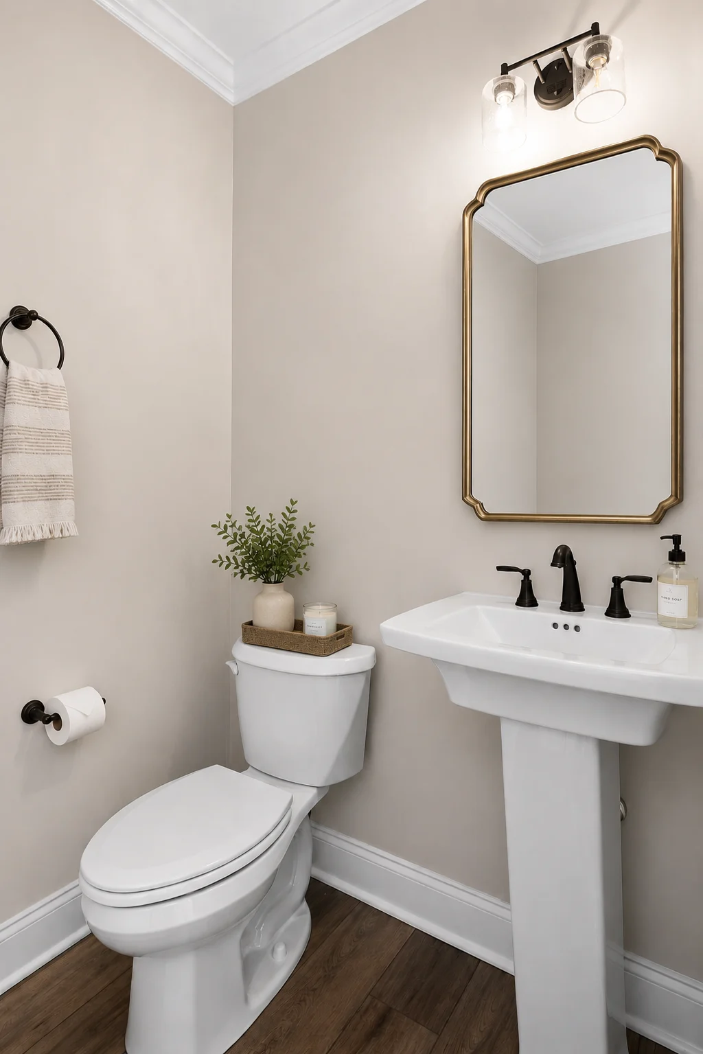 Elegant bathroom with pedestal sink, bronze fixtures, and a decorative mirror. Built by Pratt Home Builders in Chattanooga TN.