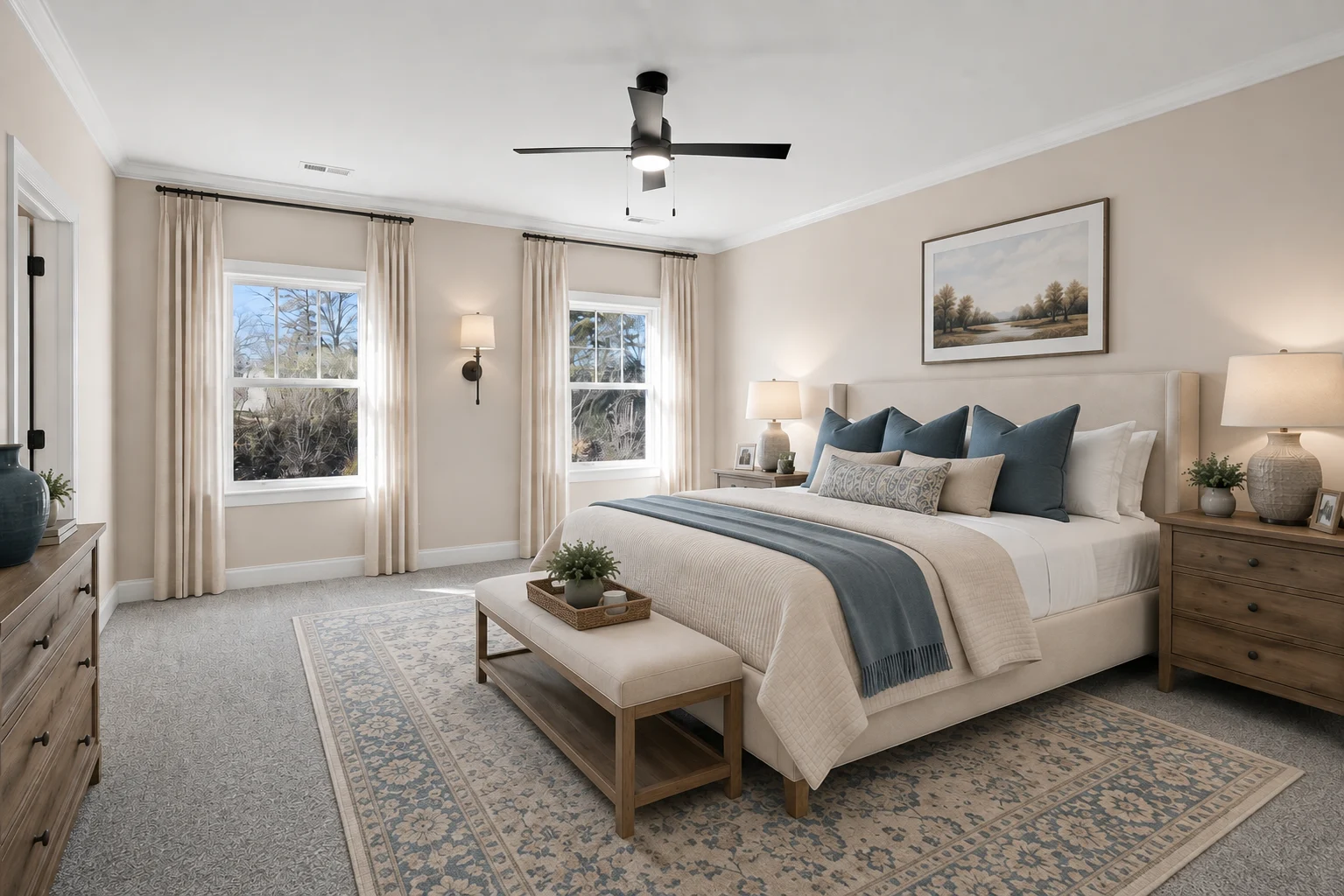 Elegant bedroom with neutral tones, blue accents, and modern decor by Pratt Home Builders in Chattanooga TN; large windows and ceiling fan.