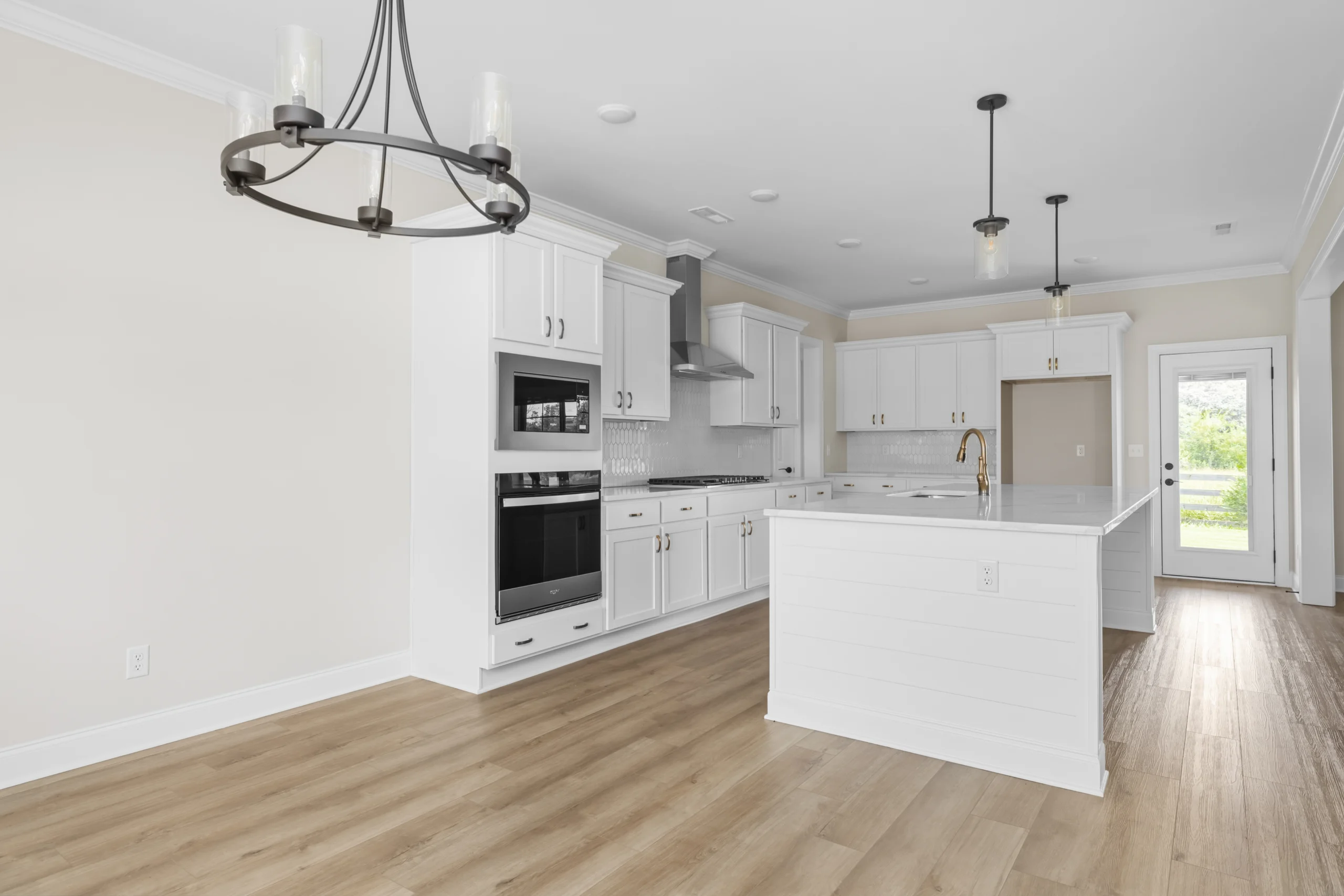 Bright, modern kitchen by Pratt Home Builders in Chattanooga TN, featuring white cabinets, stainless steel appliances, and a large island.