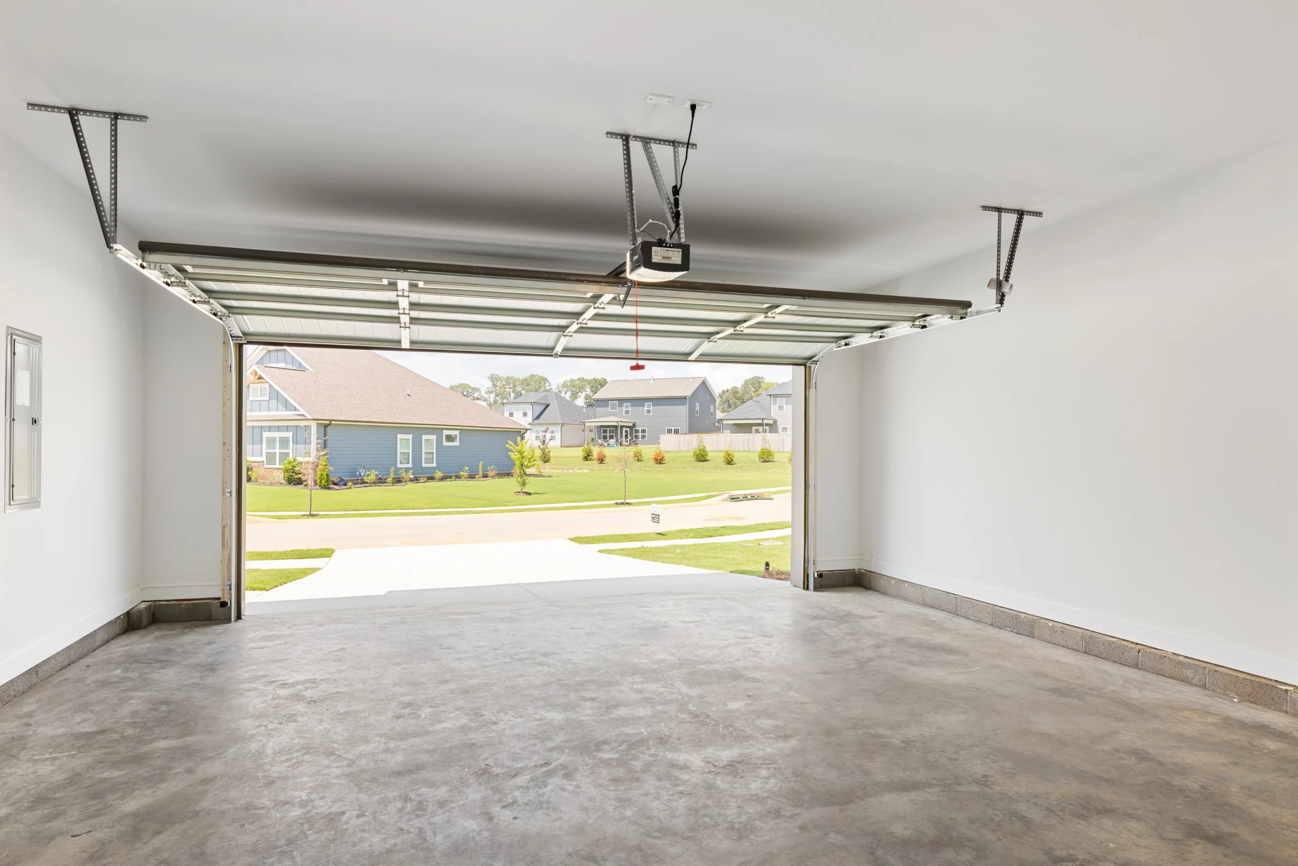 Open garage with concrete floor, overlooking a suburban neighborhood. Built by Pratt Home Builders in Chattanooga TN.