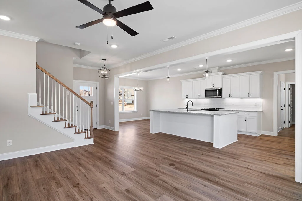 Spacious open-plan kitchen and living area with modern fixtures and hardwood floors by Pratt Home Builders in Chattanooga, TN.