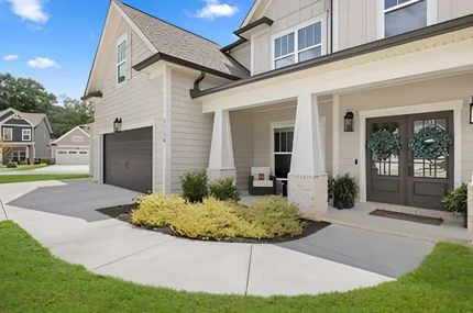 Modern suburban home with a welcoming front porch, lush landscaping, and a spacious driveway, built by Pratt Home Builders in Chattanooga TN.