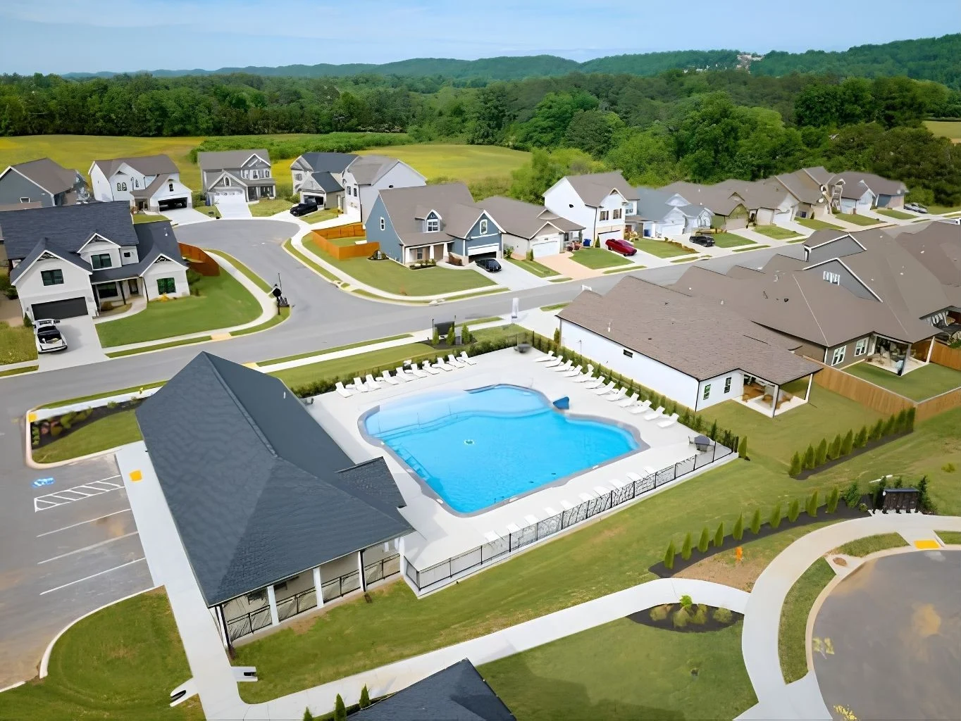 Aerial view of a suburban neighborhood in Chattanooga, TN, featuring a large community pool built by Pratt Home Builders, surrounded by homes and gree