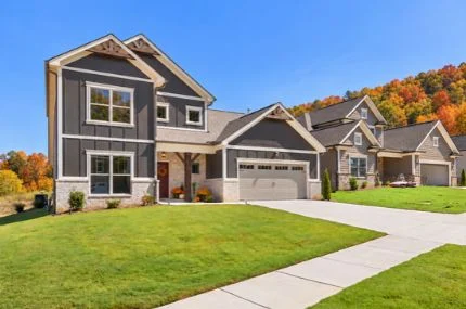 Pratt Living Blog Images (1) Modern two-story home by Pratt Home Builders in Chattanooga, TN, featuring a manicured lawn, spacious driveway, and autumn trees in the background.